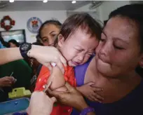  ??  ?? MABILIS LANG TO BABY! Umiyak ang bata nang bakunahan laban sa tigdas, sa isang health center sa Baseco compound sa Maynila.