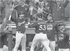  ?? JON DURR/USA TODAY SPORTS ?? Brewers relief pitcher Brandon Woodruff celebrates with left fielder Ryan Braun, left, after Woodruff homer on Friday off three-time Cy Young winner Clayton Kershaw of the Dodgers.