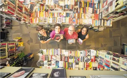  ?? Photo / Jason Oxenham ?? Store staff Briar Lawry, Niki Ward, Daniel Devenny and Melanie O’Loughlin in a sea of books.