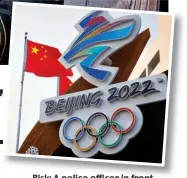  ?? ?? Risk: A police officer in front of the mascot for the 2022 Winter Olympics, and the logo