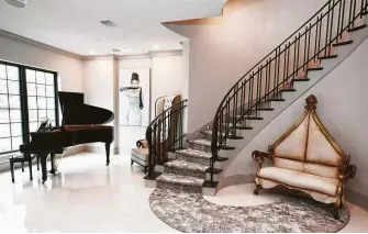  ??  ?? The grand piano, spiral staircase and antique settee make a dramatic entrance in Clifton’s Somerset Green home.