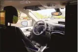  ??  ?? A Waymo minivan moves along a city street as an empty driver’s seat and a moving steering wheel drive passengers during an autonomous vehicle ride in Chandler, Arizona. (AP)