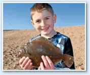  ??  ?? Jack Hardwick, shows off a nice plaice that he caught during a shore session. The nine-year-old, from Trowbridge, Wilts, was fishing with his brother Harry at West Bexington on the mighty Chesil Beach in Dorset.