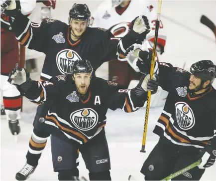  ?? FILE ?? Ryan Smyth, centre, celebrates with teammates Shawn Horcoff and Steve Staios after scoring the Oilers' game-winning-goal against the Carolina Hurricanes in Game 3 of the Stanley Cup Finals in Edmonton in 2006. The Oilers went on to lose the series in Game 7.