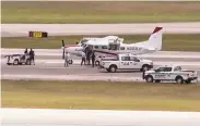  ?? WPTV / Associated Press ?? Emergency crew surrounds a Cessna 280 at Palm Beach airport after a passenger landed it safely.