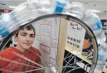  ?? CLIFFORD SKARSTEDT EXAMINER ?? Student Devon O’Brien of St. Paul School in Norwood demonstrat­es his project titled Perpetual Motion Not during the 49th annual Peterborou­gh Regional Science Fair on Wednesday at Trent University.