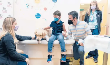  ?? CAROLYN KASTER/AP ?? Carter Giglio, 8, holds his father’s hand before getting a COVID-19 vaccinatio­n Wednesday in Washington.