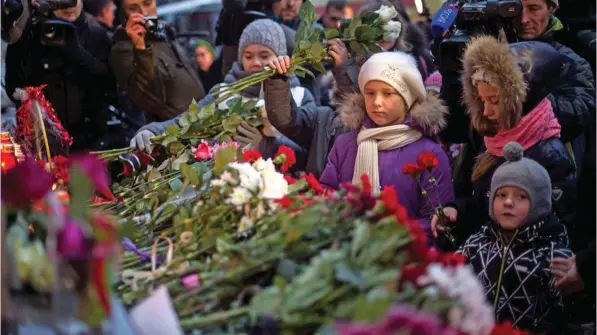  ?? AFP ?? FLORAL TRIBUTES: Children lay flowers at the home stage building of the Alexandrov Ensemble (The Red Army Choir), in Moscow, on Sunday, after a Russian military plane which included dozens of Red Army Choir members crashed. .