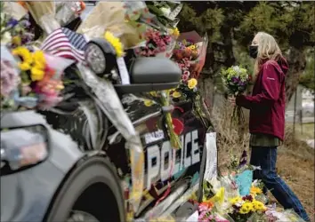  ?? Chet Strange Getty Images ?? A MOURNER pays respects at a memorial to Officer Eric Talley, one of 10 people killed by a gunman at a store in Boulder, Colo. The attack, just days after mass shootings in Georgia, renewed calls for gun control.