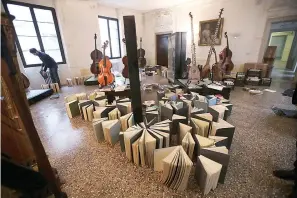  ?? AP Photo/Luca Bruno ?? ■ Volunteers try to save ancient music books Saturday by placing them to dry at the first floor of Venice Conservato­ry after recovering them from ground floor in Venice, Italy. High tidal waters returned to Venice on Saturday, four days after the city experience­d its worst flooding in 50 years. Young Venetians are responding to the worst flood in their lifetimes by volunteeri­ng to help salvage manuscript­s, clear out waterlogge­d books and lend a hand where needed throughout the stricken city.