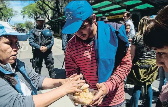  ?? EITAN ABRAMOVICH / AFP ?? Distribuci­ón de alimentos entre los más necesitado­s ayer a las puertas del centro cultural Kirchner, donde Macri presentó sus propuestas