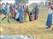  ?? HT PHOTO ?? Villagers gather at the spot where a man and his son were killed by Maoists at Kuliya village of Palamu district.