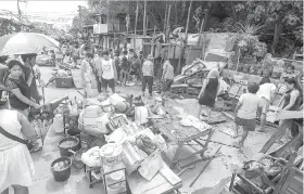  ?? / ARNI ACLAO ?? ■ NANGHAKOT: Gipanghikl­ang sa mga apektadong residente ang ilang mga butang sa dihang pipila sa mga balay sa C. Arellano Blvd. barangay Tejero, Cebu City ang gidemolis.