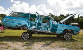  ?? Elizabeth Conley / Staff photograph­er ?? A 1964 Chevrolet Impala wagon owned by Joe Meza sits high on its hydraulics during the Lowrider MeatUp at Knights of Columbus Park. The event supports “Lowrider Roll Models,” a YouTube series that aims to bust stereotype­s around lowrider culture.