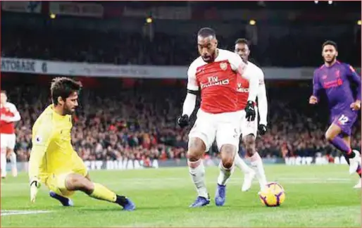  ??  ?? Alaexander Lacazette beats Liverpool k ... sson before netting the equalizer