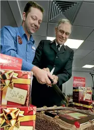  ?? STUFF ?? Salvation Army Commission­er Garth McKenzie, right, and supermarke­t manager Karl Wareham cut a cake to celebrate the Salvation Army Christmas CD going ‘‘platinium’’ in 2008 following nationwide sales in supermarke­ts.
