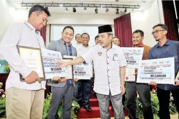  ??  ?? Tajuddin (middle) socialises with other farmers during the launch of the Farmers’ Organisati­on Authority’s campaign to promote youths’ participat­ion in farmers’ organisati­ons here yesterday. — Bernama photo