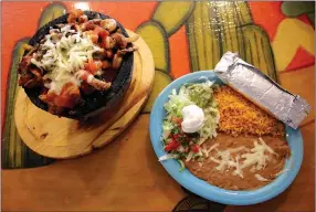  ?? MEGAN DAVIS/MCDONALD COUNTY PRESS ?? Ortega’s self-confessed favorite menu item is the molcajete — chicken, steak and shrimp served in a simmering volcanic rock bowl topped with onions, bell peppers and tomatoes, covered in ranchero sauce and shredded cheese then served with tortillas, rice, beans, guacamole, sour cream, pico de gallo and all the fixings.