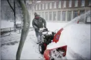  ?? BRIANA SANCHEZ — THE ARGUS LEADER VIA AP ?? James Schoenhard, with Schoenhard Lawn Care, plows sidewalks with his team downtown Saturday, April 14, in Sioux Falls, S.D.