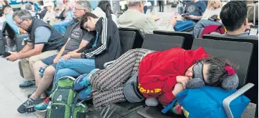  ??  ?? Hundreds of weary travellers attempted to catch up on some much-needed sleep at the airport