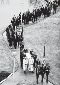  ?? JEFF ROBERSON/GETTY ?? The flag-draped casket of former President George H.W. Bush is carried by a joint services honor guard followed by family members Thursday in College Station, Texas.