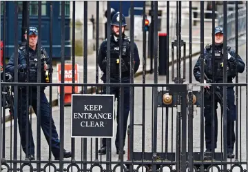  ??  ?? TOMMY-GUN GUARDS: Armed officers stand behind the elaborate metal gates of Downing Street