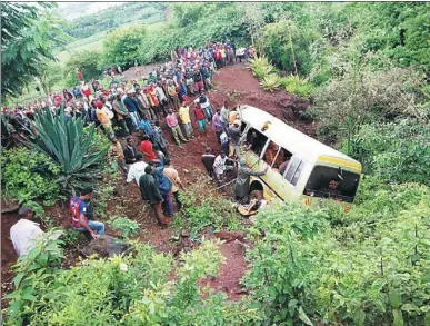  ?? EMMANUEL HERMAN / REUTERS ?? Residents gather at the scene of an accident that killed 32 primary school pupils, two teachers and the vehicle’s driver at the Rhota village along the Arusha-Karatu highway in Tanzania’s northern tourist region of Arusha on Saturday.