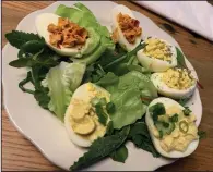  ?? (Arkansas Democrat-Gazette/Eric E. Harrison) ?? A flight of deviled eggs — (clockwise from bottom) two “Southern Traditiona­l,” two “Smoked” and two “Library Style” — come on a bed of mixed greens.