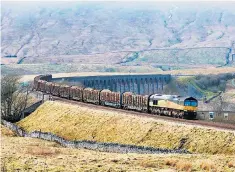  ??  ?? A trainload of timber on the curve from Ribblehead viaduct on the Settle to Carlisle line