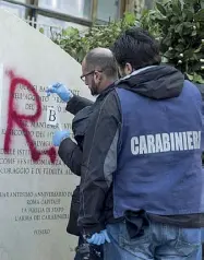  ??  ?? Rilievi I tecnici dei carabinier­i analizzano una delle iniziali delle Brigate Rosse scritte sulla lapide in via Fani