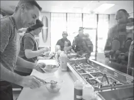  ?? NEWS-SENTINEL PHOTOGRAPH­S BY BEA AHBECK ?? Paul Polhemus prepares a bowl for a customer at Loco Poke in Lodi.