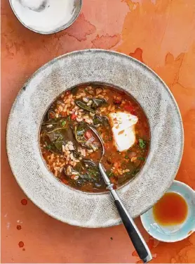  ?? Beatriz da Costa via Associated Press ?? Collard greens and rice soup, a recipe from “The Simple Art of Rice,” above left, by chef JJ Johnson and Danica Novgorodof­f.