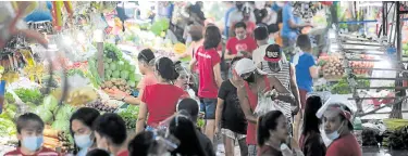  ?? — GRIG C. MONTEGRAND­E ?? LAST-MINUTE SHOPPING People flock to Commonweal­th Market in Quezon City on Thursday for last-minute shopping for the traditiona­l Christmas Eve repast. They forget physical distancing, despite a plea from the local government for them to observe public health measures to prevent a rise in coronaviru­s infections after the holidays.