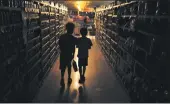  ??  ?? KENT PORTER — THE PRESS DEMOCRAT FILE Elijah Carter and Robert Haralson help shop for their parents in a darkened Olivers Supermarke­t during a blackout in Santa Rosa.