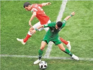  ?? AFP ?? El ruso Semenov y el saudí Mohammed Al-Breik, ayer en el partido inaugural del Mundial de Rusia que ganaron los rusos por 5-0