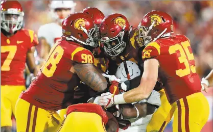  ?? PHOTOS BY SEAN M. HAFFEY — GETTY IMAGES ?? The USC defense swarms around a Stanford ball carrier. The Cardinal running game has gone from effectivel­y methodical to boom-or-bust.