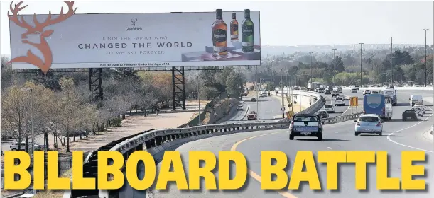  ?? PICTURE: DUMISANI SIBEKO ?? DON’T READ AND DRIVE: A billboard at Gillooly’s Farm near Bedfordvie­w, Joburg, has opened a can of worms regarding the hazards of roadside advertisin­g.THE SOUTH African National Roads Agency Ltd (Sanral) is at loggerhead­s with the City of Ekurhuleni over numerous illegal billboards the municipali­ty has approved on bridges and along freeways, particular­ly along the R21 towards OR Tambo Internatio­nal Airport.And in what has been described as a bizarre situation, four internal Ekurhuleni department­s are at odds with one another over it.In one case, Ekurhuleni’s real estate department is opposing the outdoor advertisin­g department that approved a giant 91m2 billboard on Gillooly’s Farm, targeting the busy Gillooly’s interchang­e.The real estate department has requested the legal department to interdict the applicants who erected it, forcing them to remove it.The parks department is also involved because both legs of the billboard are within the historic Gillooly’s Farm and the owners of the billboard should have entered a