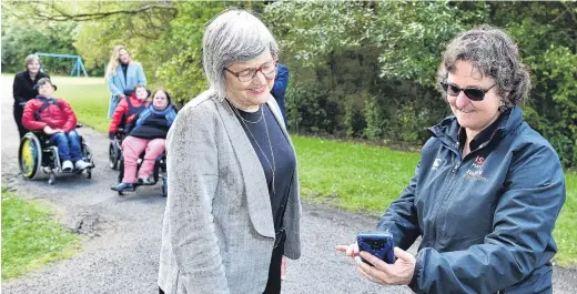  ?? PHOTO: GREGOR RICHARDSON ?? On track . . . Minister of Conservati­on Eugenie Sage and Halberg Foundation lead adviser Bridget Meyer check out the new Accessibel website at Woodhaugh Gardens yesterday.