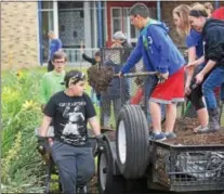  ?? PETE BANNAN – DIGITAL FIRST MEDIA ?? West Bradford scouts from Boy Scout Troop 52, Cub Scout Troop 152, Girls Scout Brownies 4029 and Cadets 493 spent Thursday evening hauling wheelbarro­ws of mulch in memory of their friend Tommy Slater.