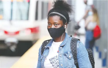  ?? BRENDAN MILLER ?? A woman wears a face mask at the City Hall LRT Station on Friday. Studies show they are a key to impede the spread of COVID-19.