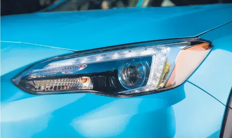  ?? SUBARU ?? The 2019 Subaru Crosstrek Hybrid has blue headlight projector rings and a silver metallic finish on the front grille, lower front bumper and body cladding, and fog light accents.