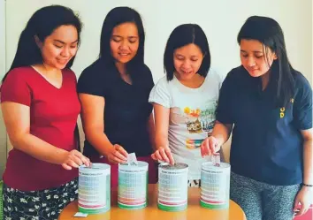  ??  ?? Sheryl Lopez and friends with their #IponChalle­nge cans with the ‘save and shade’ template printed on them. Savers shade the box correspond­ing to the money they’re putting in the can.