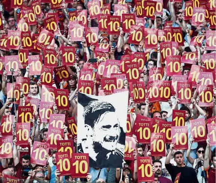  ?? — Reuters ?? Ultimate adoration: AS Roma fans display a banner and the number 10 of club legend Francesco Totti after the final match of his career against Genoa at the Olympic Stadium in Rome on Sunday.