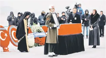  ??  ?? An orthodox clergyman prays next to the flag-wrapped coffin of late Russian Ambassador to Turkey Andrei Karlov during a ceremony at Esenboga airport in Ankara, Turkey. — AFP photo