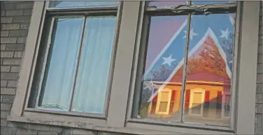  ??  ?? A confederat­e flag hangs in the window of a home of a young Black woman in Shawnee, Ohio, on July 28. Confederat­e flags have become a symbol of a certain America: white, often rural, sometimes southern, normally conservati­ve. This time, though, it turned out to be a young Black woman who was flying it. She said it was her way of “giving the finger” to everyone, including white Southerner­s who believe they control the flag and its symbolism.