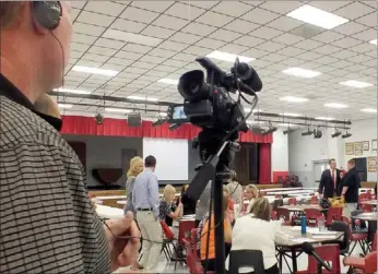  ?? Times photograph by Annette Beard ?? Mark Laster, left, sets up the camera as band director Matt McCool helps superinten­dent Rick Neal with a microphone before Neal addresses teachers Tuesday morning before breakfast. Laster will be teaching audio-visual classes at Pea Ridge High School...