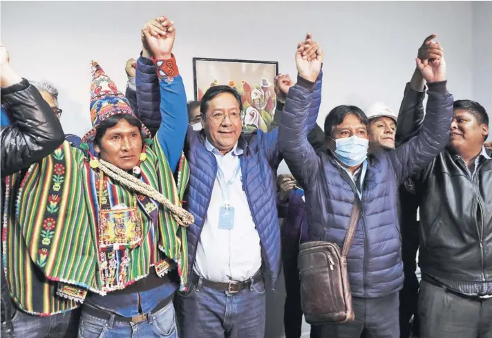  ??  ?? ► El ganador de las elecciones bolivianas, el exministro de Economía Luis Arce (al centro), y su compañero de fórmula, David Choquehuan­ca (con mascarilla) el domingo.