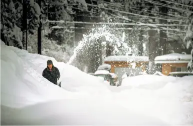  ?? AJ Marino / Novus Select / Special to The Chronicle ?? Rick Staff uses a snowblower to dig out after a storm blanketed South Lake Tahoe. The atmospheri­c river that brought incessant rain to the Bay Area is moving through the Sierra region.