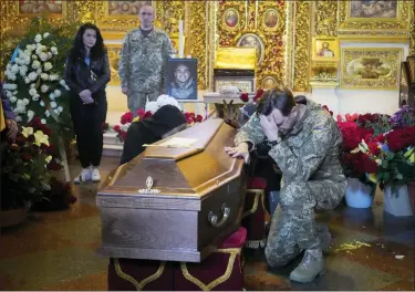  ?? EFREM LUKATSKY — THE ASSOCIATED PRESS ?? A soldier pays his last tribute to volunteer soldier Oleksandr Makhov, 36, a well-known Ukrainian journalist, killed by Russian troops, during his funeral at St Michael cathedral in Kyiv, Ukraine, on Monday. Russian invaders continue to face stiff resistance from Ukrainian forces.