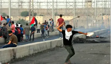  ?? — AFP photo ?? A man uses a slingshot as Palestinia­n protesters demonstrat­e at the Erez border crossing with Israel in the northern Gaza Strip.